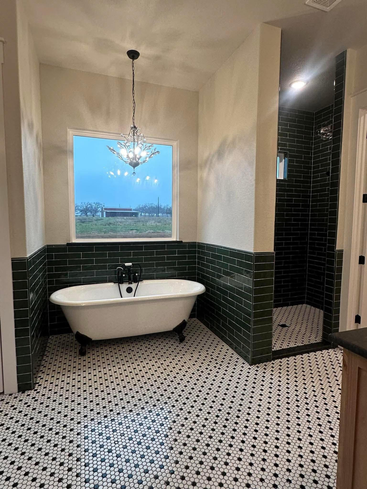 Master bathroom with clawfoot tub, dark green subway tile wainscoting, walk-in shower, and hex floor tile in Decatur TX