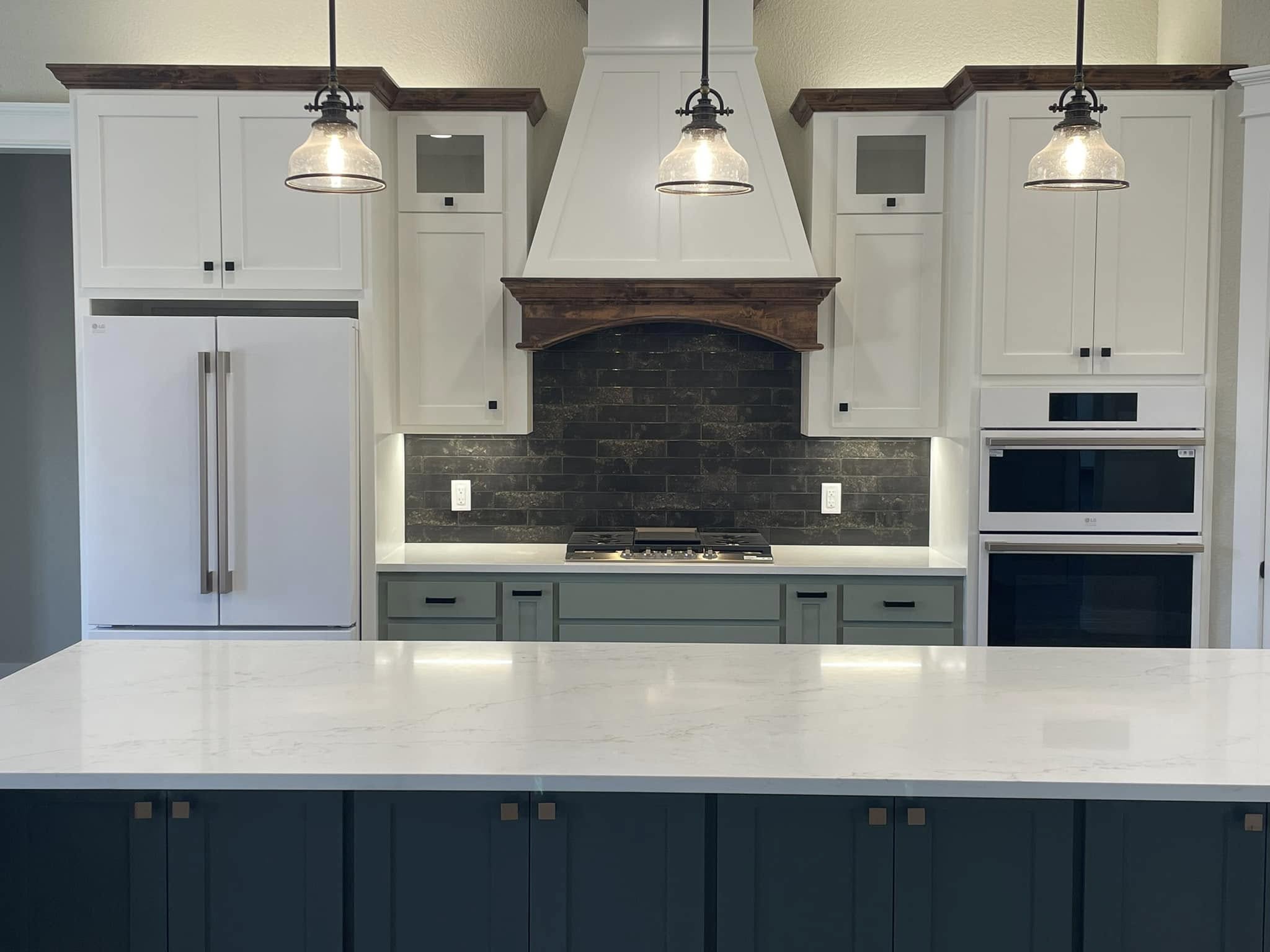 White quartz countertop with teal island base, dark tile backsplash, and farmhouse range hood in Wise County kitchen