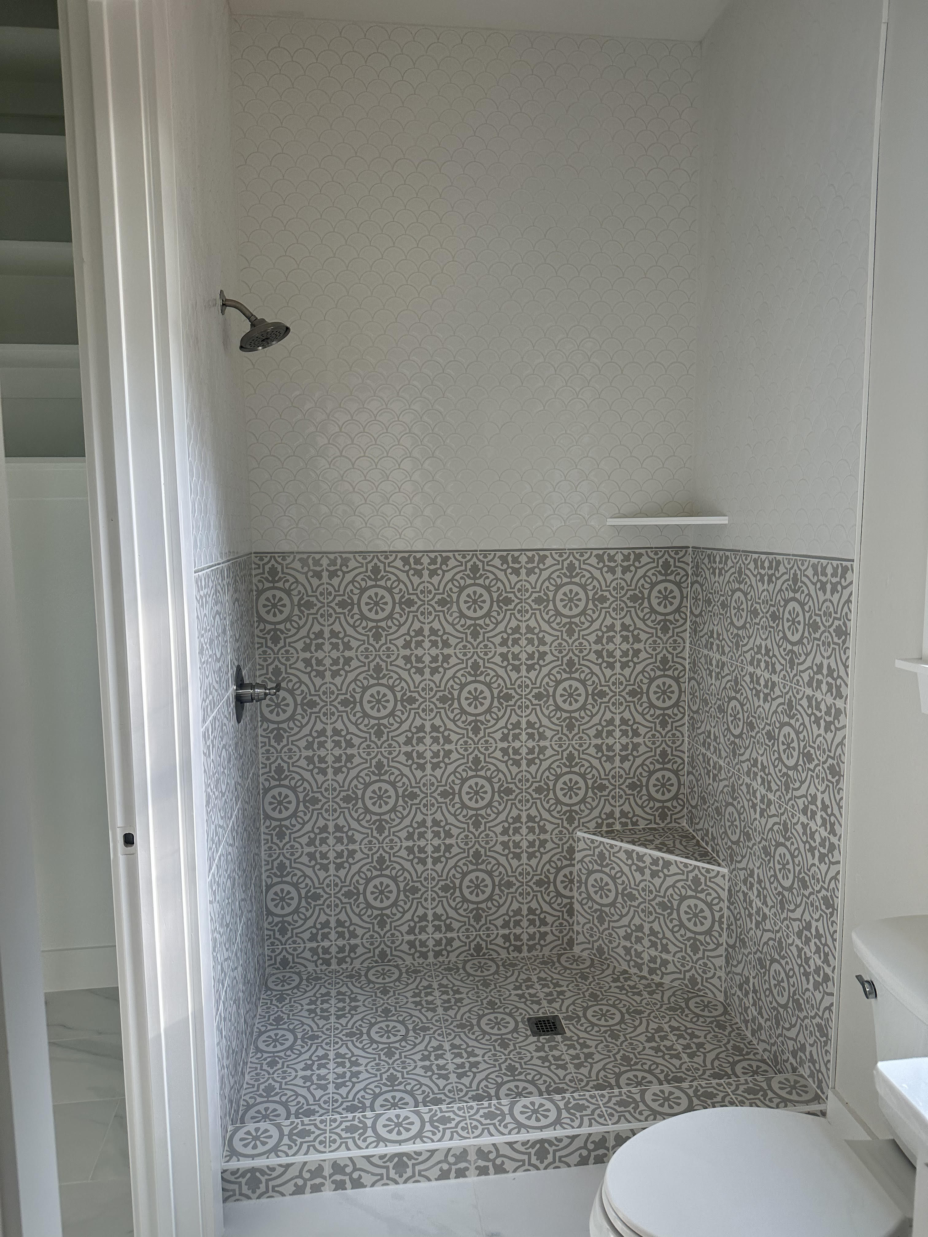 Custom fish scale and decorative pattern tile shower with built-in bench in Decatur TX bathroom