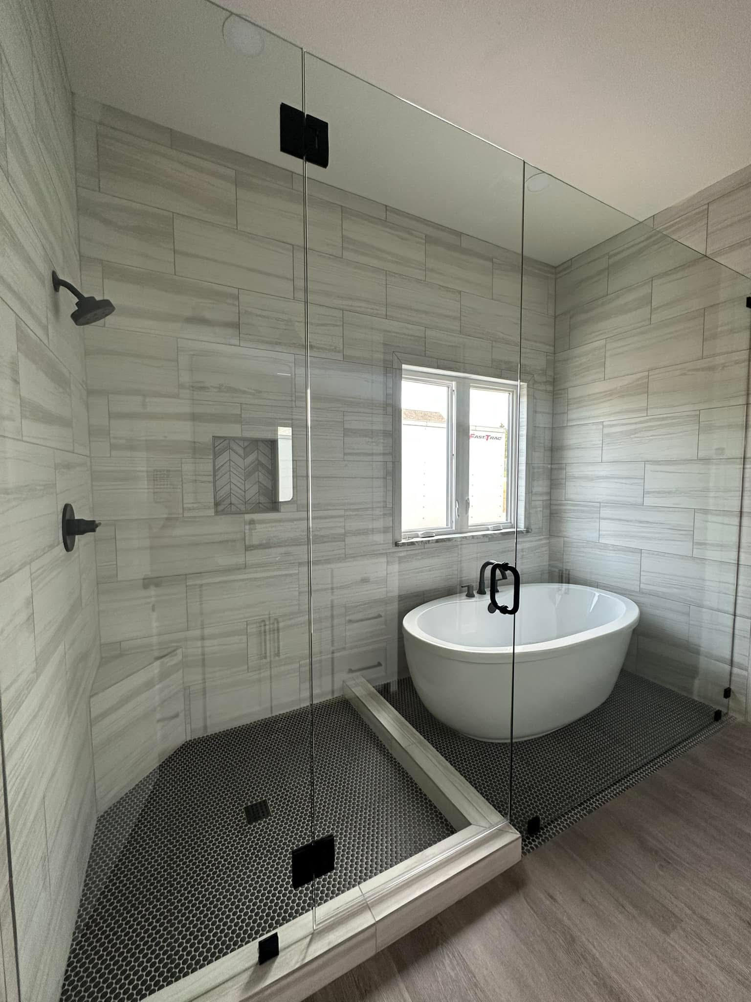 Elegant clawfoot tub with dark green subway tile wainscoting and hex penny tile floor in Decatur TX bathroom