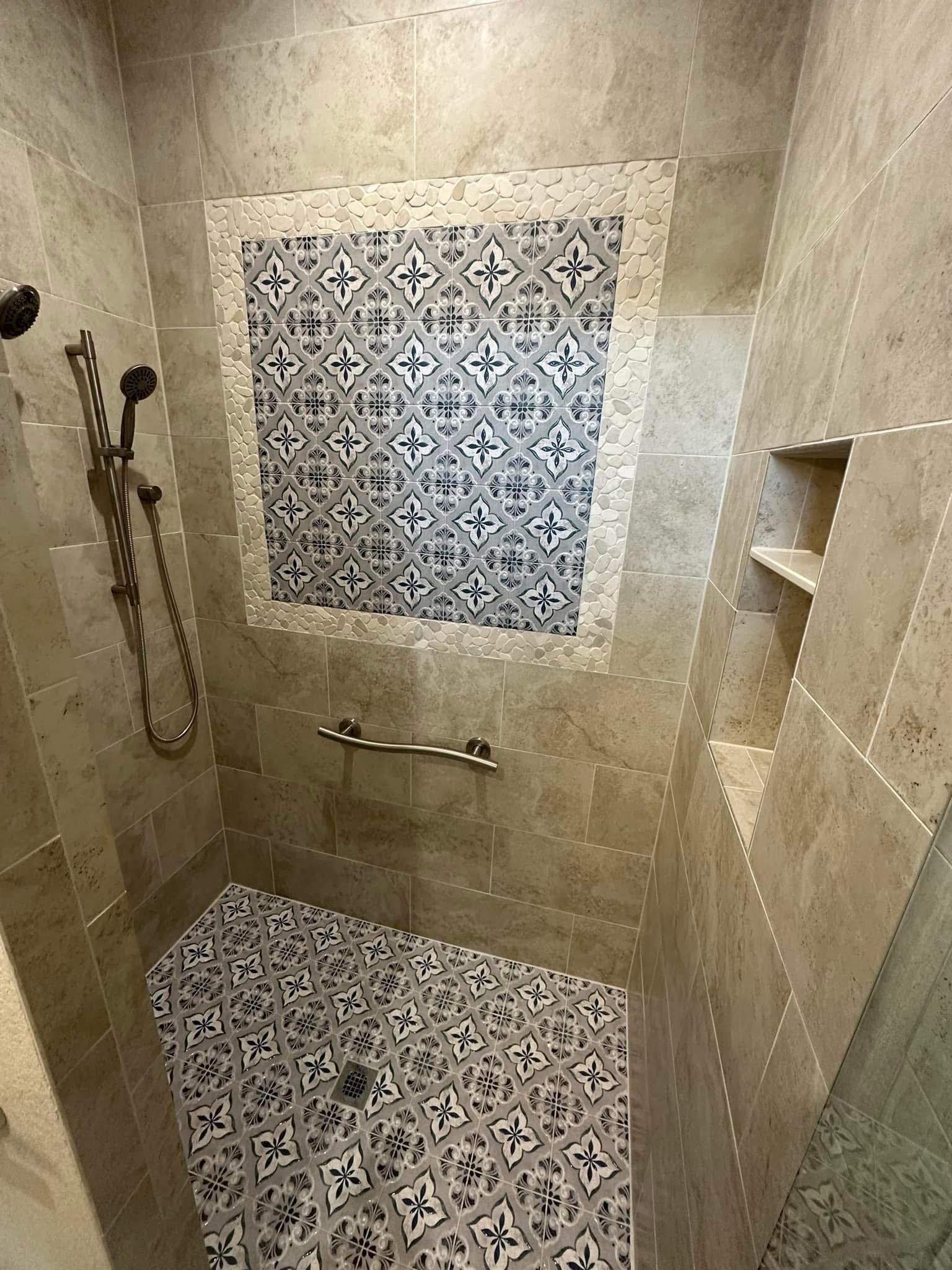 Custom tile shower with decorative mosaic accent wall and pebble border in Decatur TX bathroom