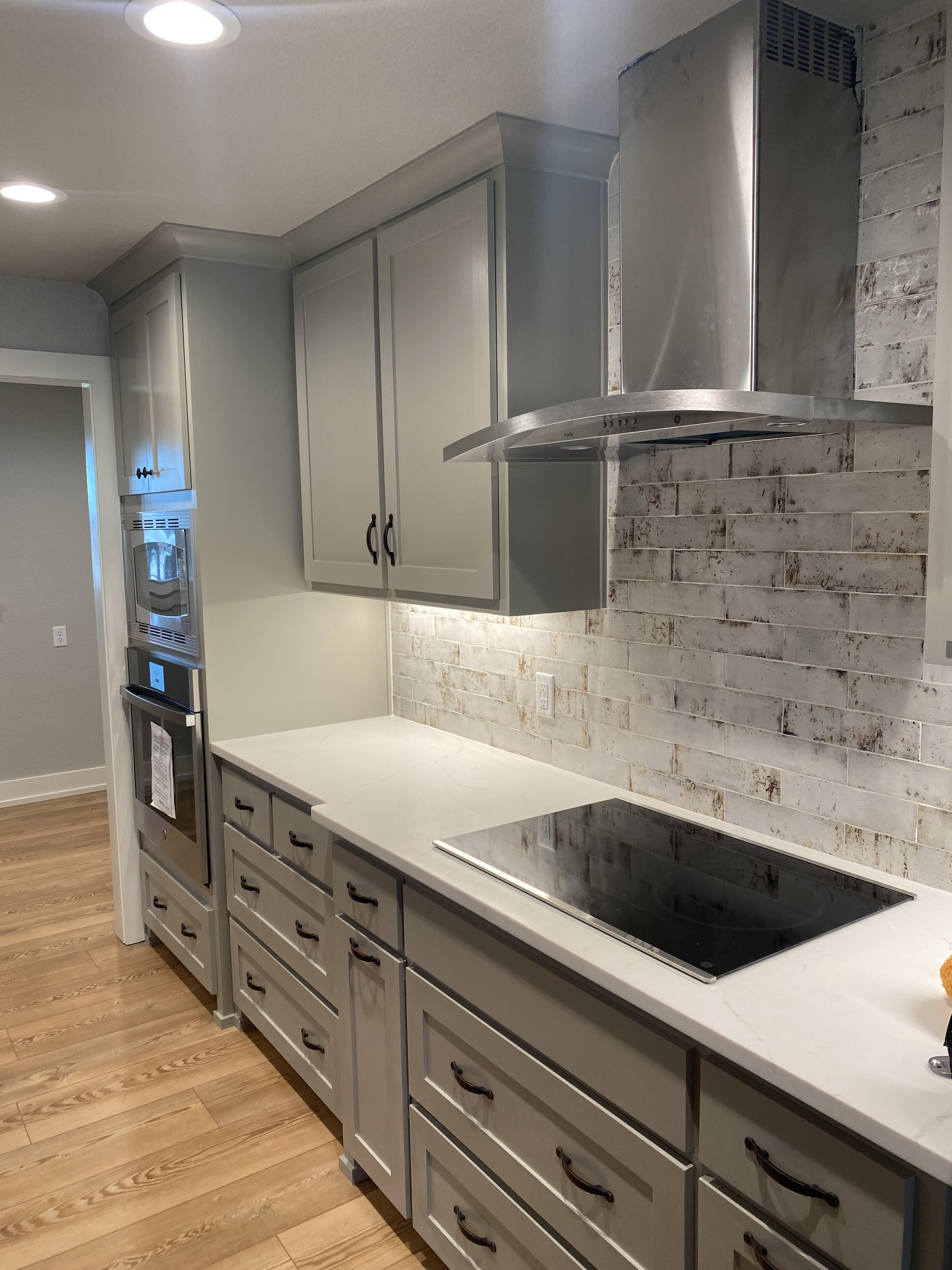 Rustic whitewashed brick tile backsplash with quartz counters and grey shaker cabinets in Decatur TX kitchen