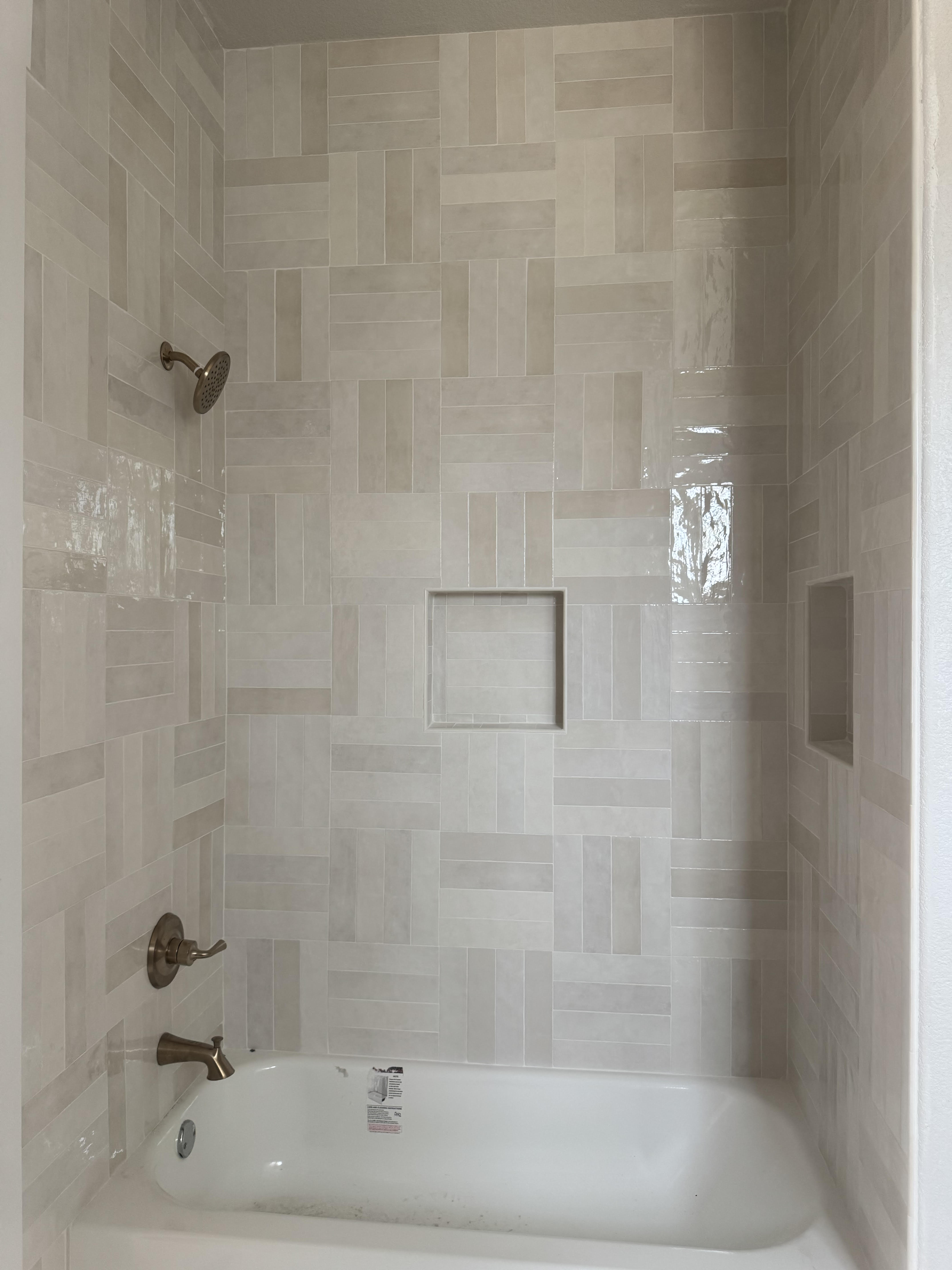 Modern tile shower with herringbone pattern subway tiles and frameless glass enclosure in Decatur TX