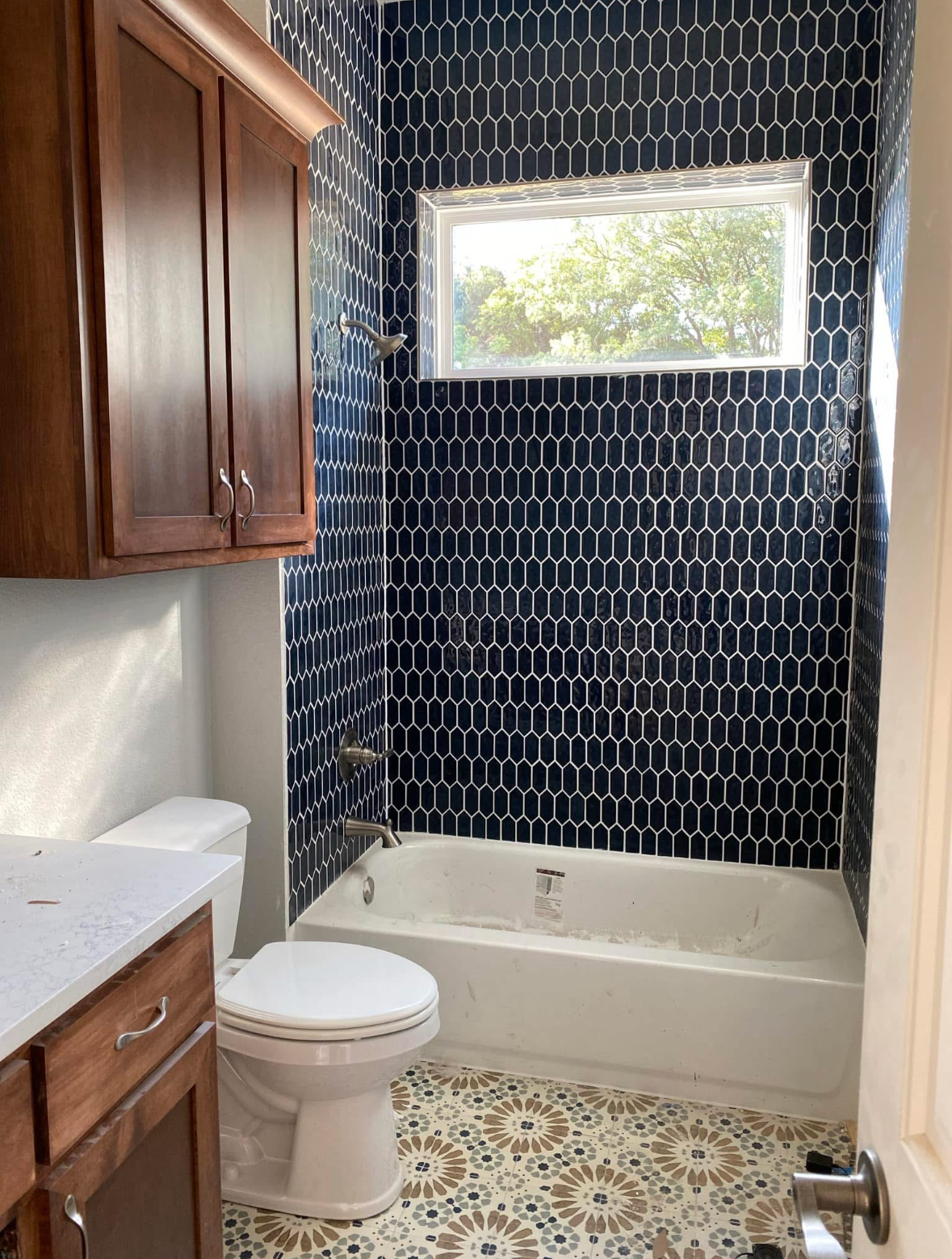 Luxury spa-like bathroom with tub, dark hexagonal mosaic tile floor, and white subway tile in Wise County